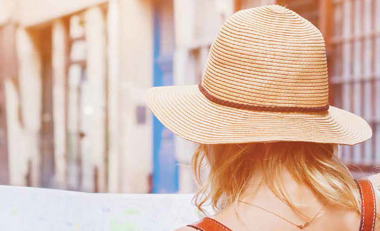 woman with summer hat walking away from camera