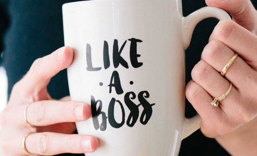 Woman holding mug inscribed with 'like a boss'